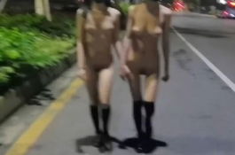 兩個女孩手牽手馬路上露出